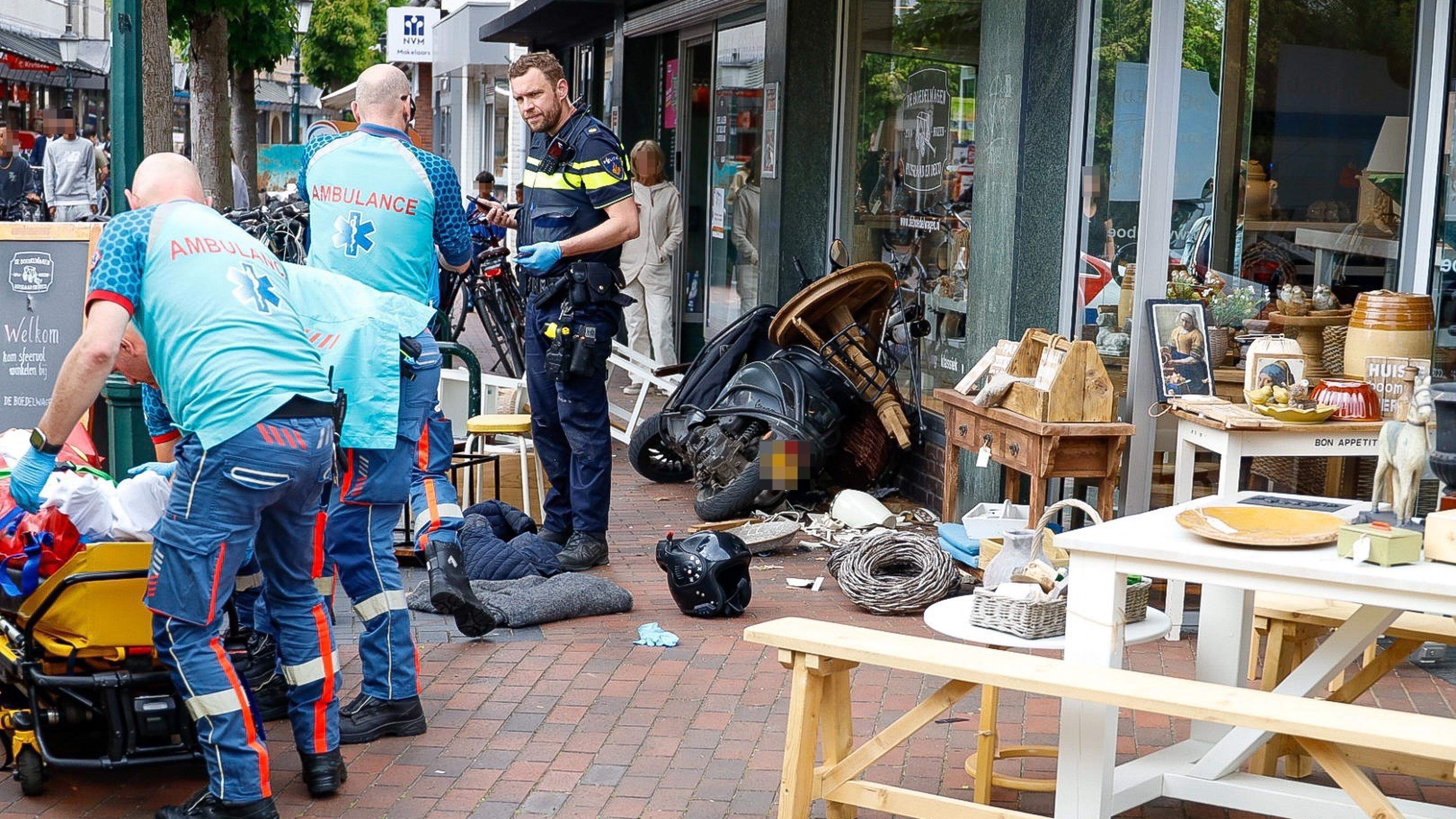 Gewonde bij botsing auto en scooter in Huizen, ravage bij woonwinkel