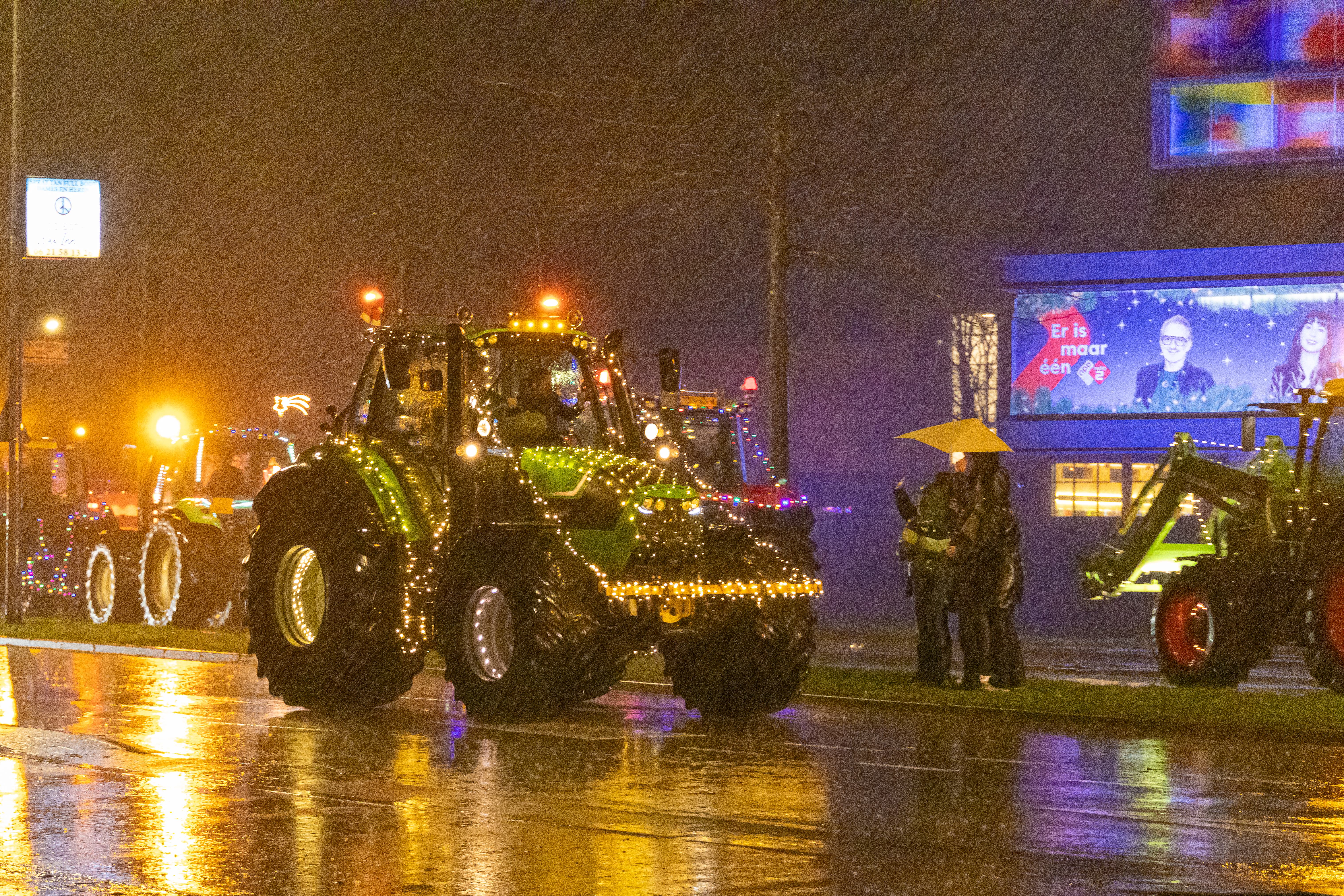 Agrariërs rijden ondanks de regen met vrolijk verlichte feeststoet. ’Statement van een springlevende
